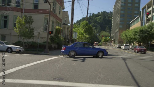 Rear view of a Driving Plate: Car is driving down Broadway Street in Portland, Oregon transitioning onto the I-405 North on ramp. The car then takes the West 30 Highway ramp towards St. Helens but stays to the right and exits onto Vaughn Street. Once thru the stop light the car turns right onto Southwest 23rd Avenue. The car then turns left and comes to a stop on Northwest Wilson Street. photo