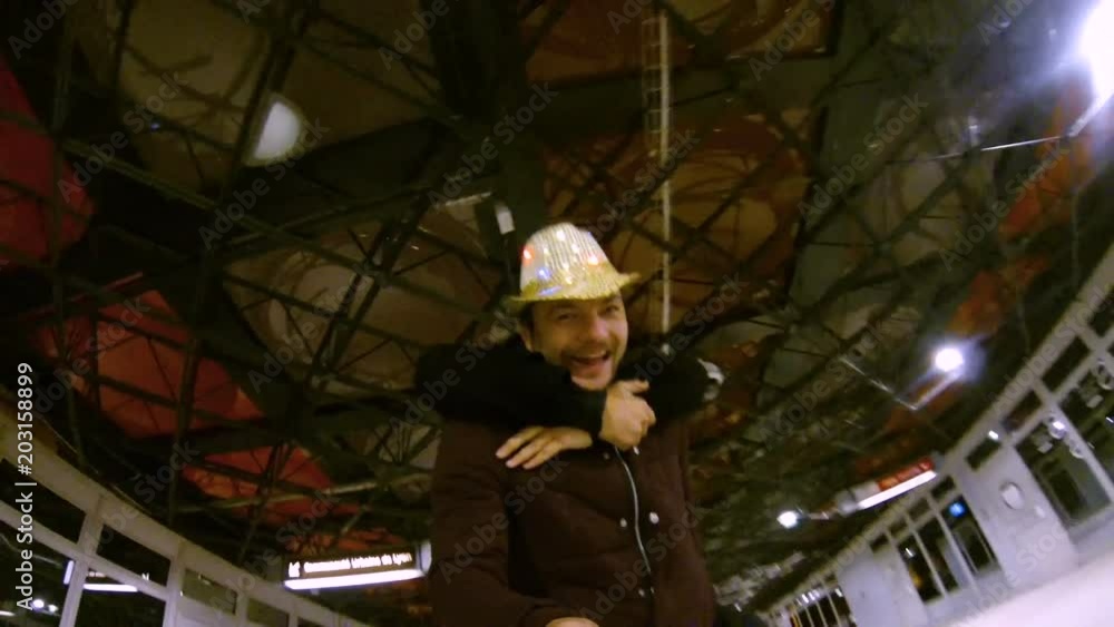 Young man taking video of self while skating, giving piggyback ride to friend Young man taking video of self while skating, giving piggyback ride to friend