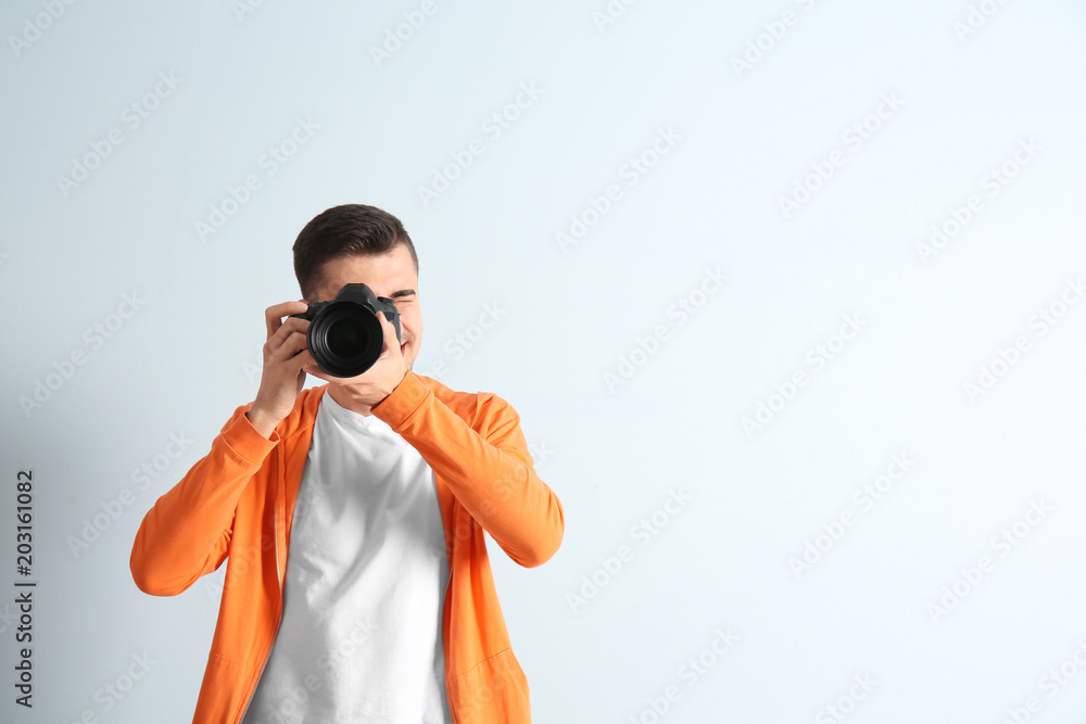 Male photographer with camera on light background Male photographer with camera on light background