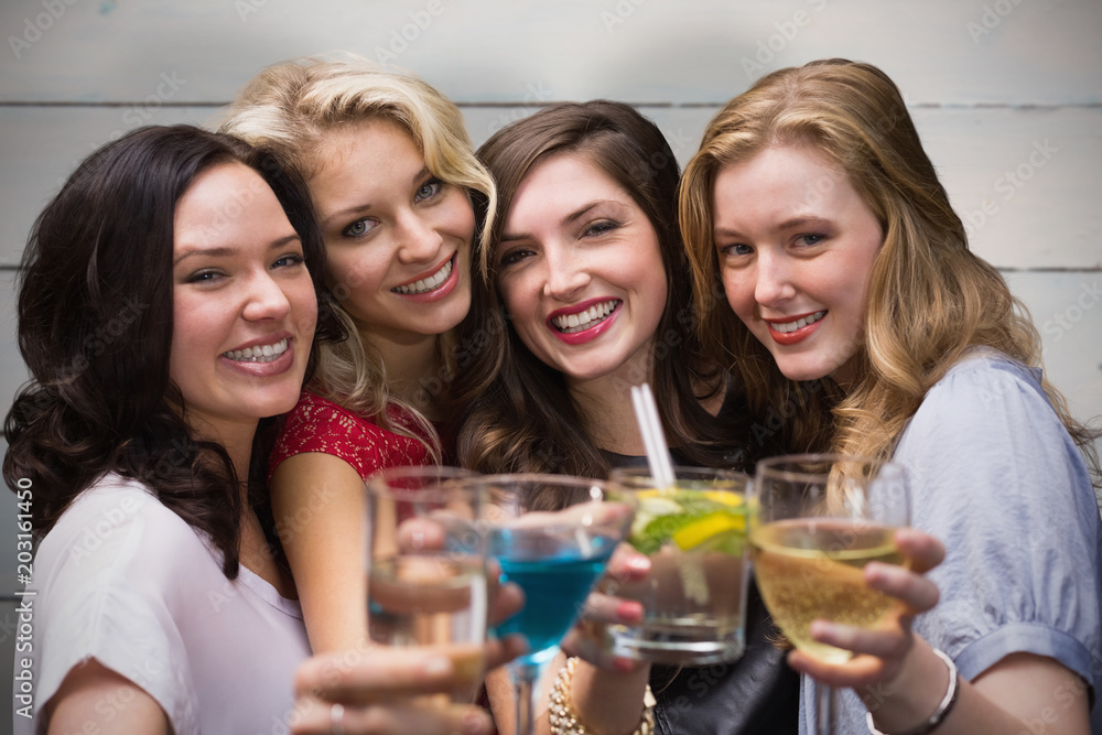 Friends with drinks against painted blue wooden planks Friends with drinks against painted blue wooden planks