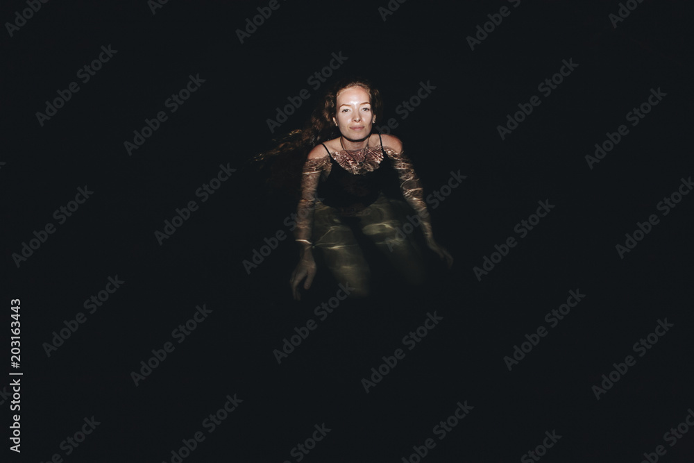 Woman swimming in the dark Woman swimming in the dark