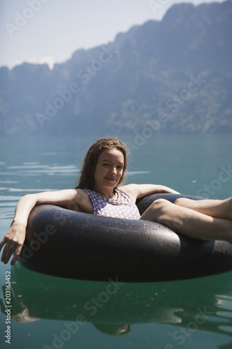 Happy woman floating around on a lake