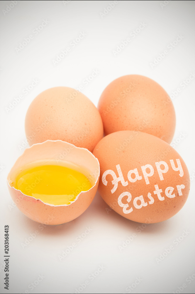 happy easter against three eggs with raw yolk in half a shell happy easter against three eggs with raw yolk in half a shell