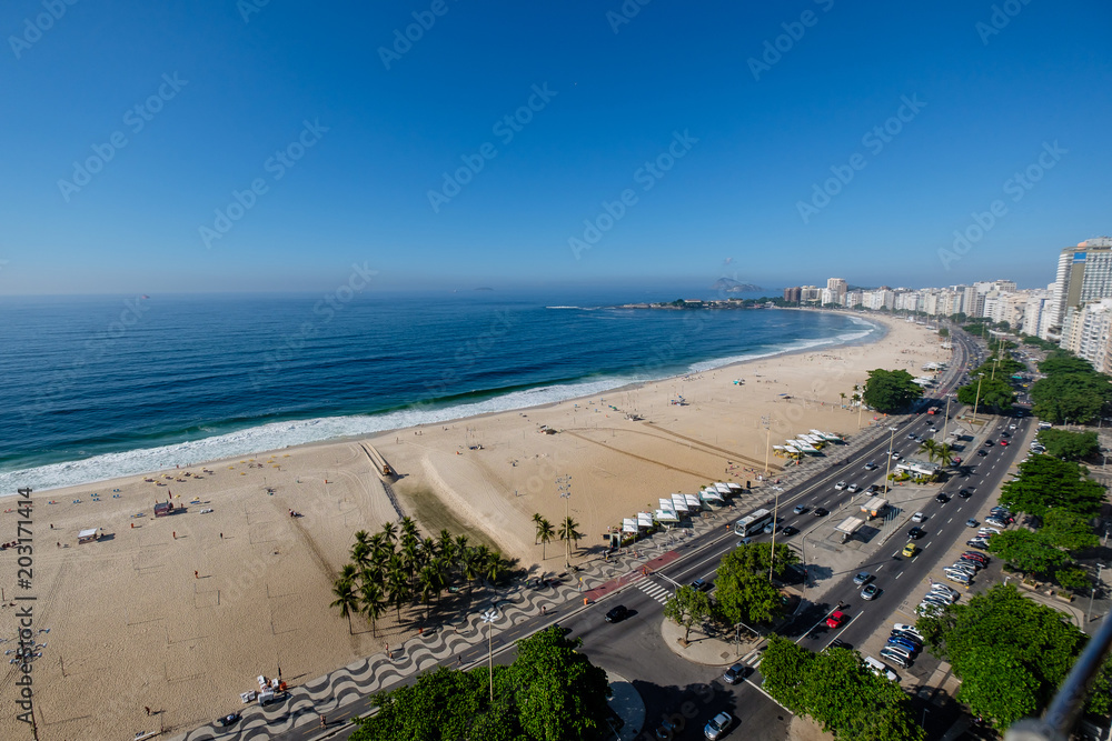 view of Copacabana beach right side during early morning, taken from the rooftop of a hotel, some slight fog can be seen on the blue sky. Rio de Janeiro, Brazil