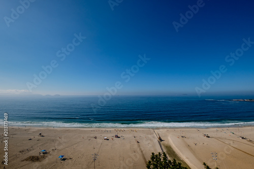view of Copacabana beach during early morning  taken from the rooftop of a hotel  some slight fog can be seen on the blue sky. Rio de Janeiro  Brazil