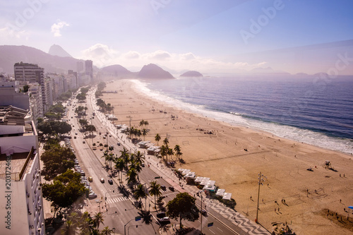 view of Copacabana beachs left side during early morning  taken from the rooftop of a hotel  some slight fog can be seen on the blue sky. Rio de Janeiro  Brazil
