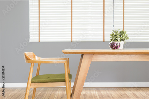 Dining table set with chair in the cozy dining room with grey wall.