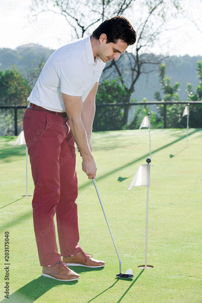 Fototapeta premium Man playing golf is going to hit ball at golf course