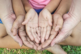 Close up open hands of man and woman and kid with palm up isolated on green grass background. Family together helping environment protection and caring