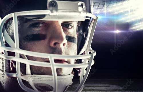 American football player looking at camera against american football arena