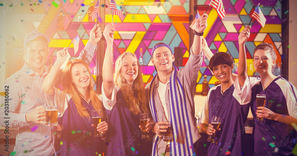 Fototapeta premium Portrait of friends holding American flag in party against flying colours