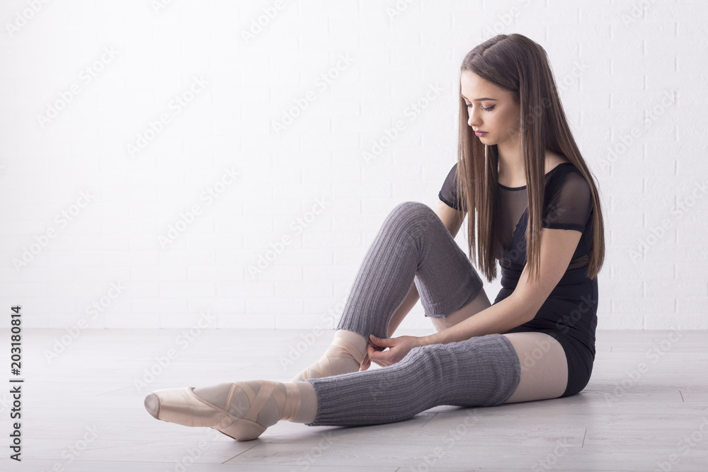 Beautiful ballet dancer sitting on the floor and prepare for performance Beautiful ballet dancer sitting on the floor and prepare for performance