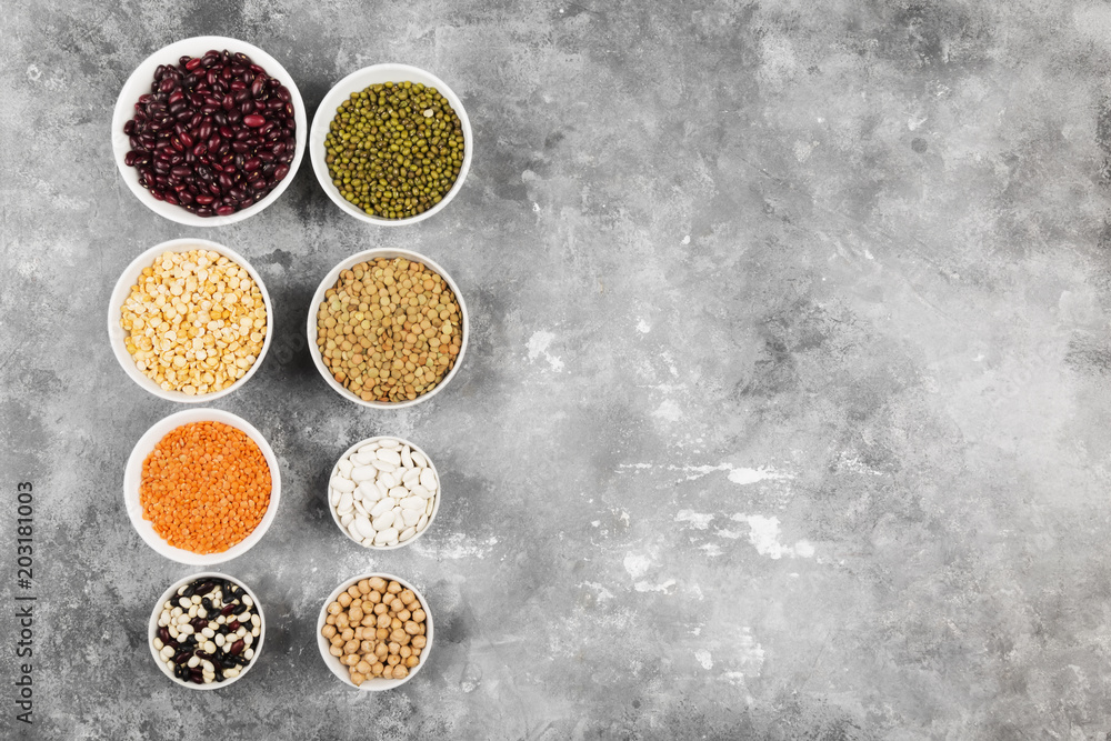 Assortment of beans (red lentil, green lentil, chickpea, peas, red beans, white beans, mix beans, mung bean) on gray background. Top view, copy space. Food background Assortment of beans (red lentil, green lentil, chickpea, peas, red beans, white beans, mix beans, mung bean) on gray background. Top view, copy space. Food background