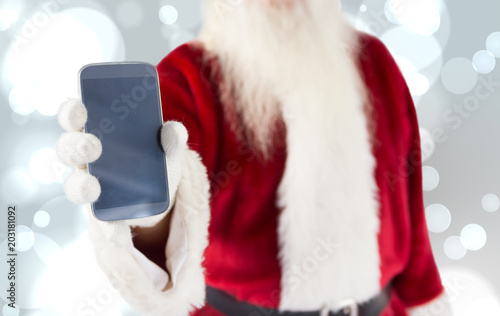 Santa claus showing smartphone against white glowing dots on grey