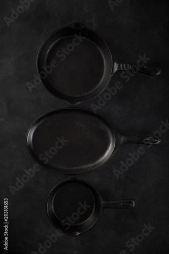 Monochrome concept. Black cast iron pans on black background