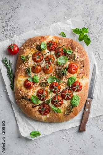 Foto italian bread focaccia with tomatoes, basil and sea salt