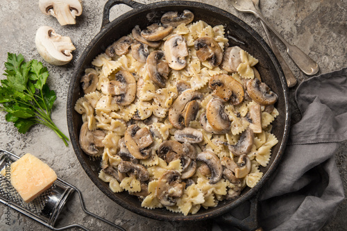 Fotografie farfalle pasta with champignon mushrooms and garlic creamy sauce on pan