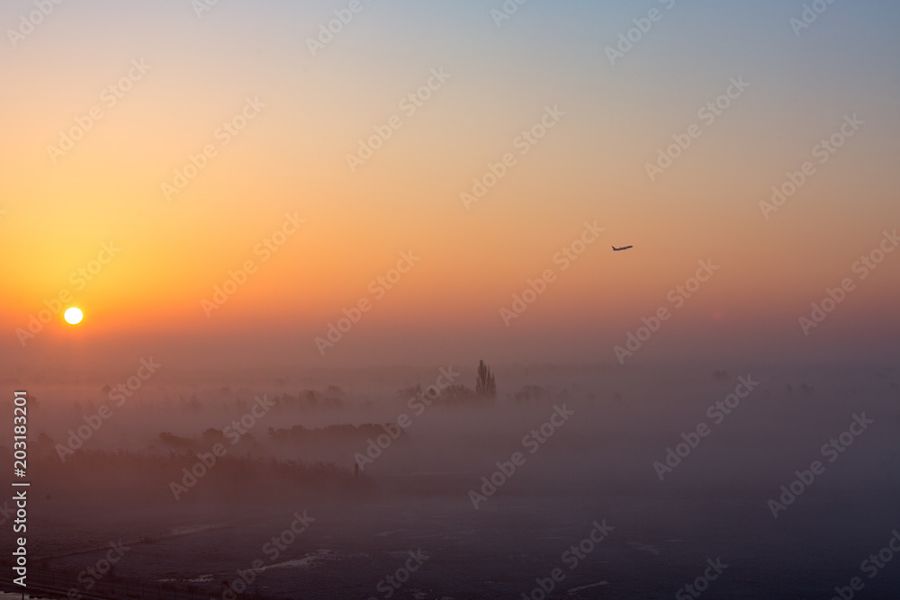 View towards Kalvebod Faelled, the airport and Amager from Oerestad early in the morning. Fog rising from the ground makes this a dreamy scene. Plane taking off from Copenhagen Airport View towards Kalvebod Faelled, the airport and Amager from Oerestad early in the morning. Fog rising from the ground makes this a dreamy scene. Plane taking off from Copenhagen Airport