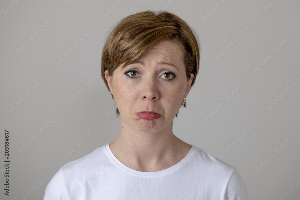 Foto de Human expressions and emotions. Young attractive woman with a sad  face, looking unhappy at the camera. do Stock | Adobe Stock