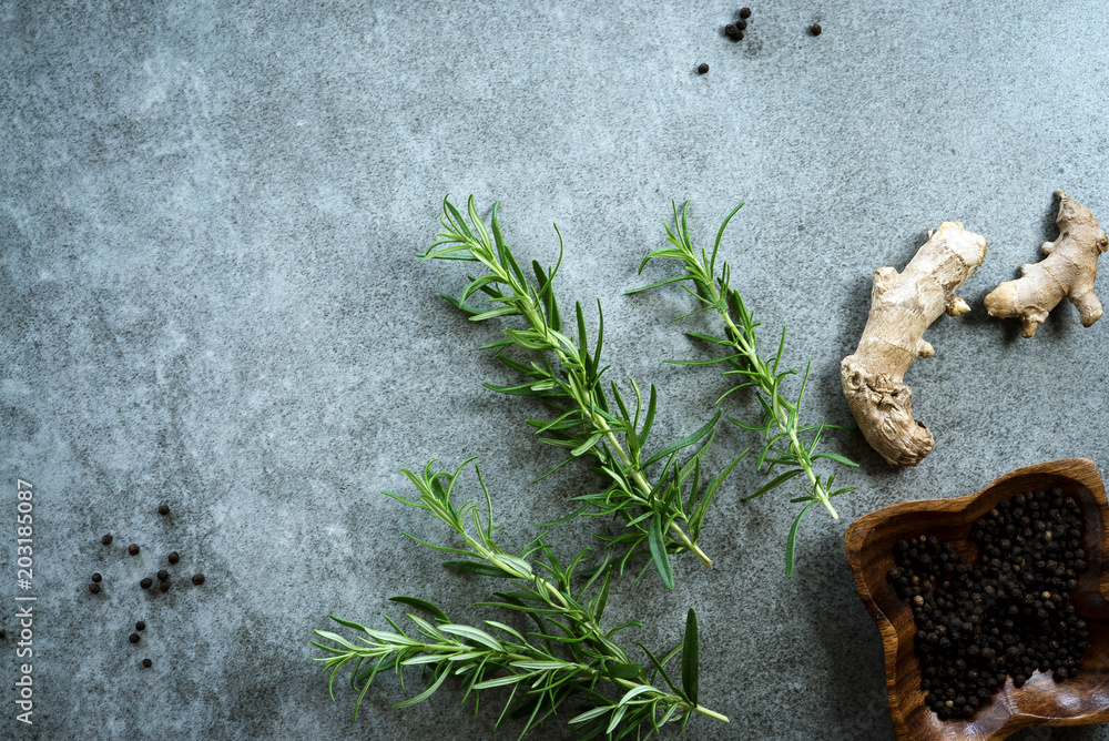 Naklejka premium Various herbs and spices on gray stone