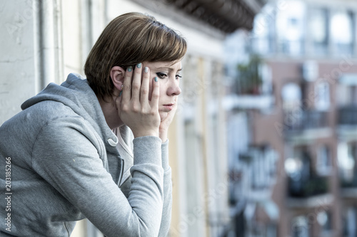young attractive unhappy depressed lonely woman looking sad on the balcony at home photo