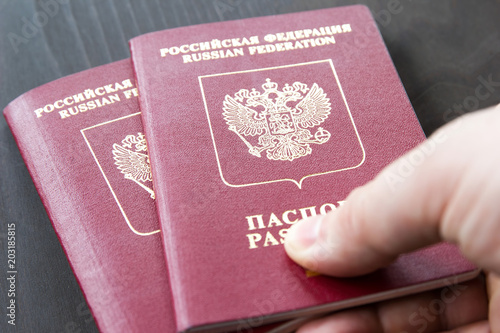 Two russian passports in hand. Russian official document on dark background photo