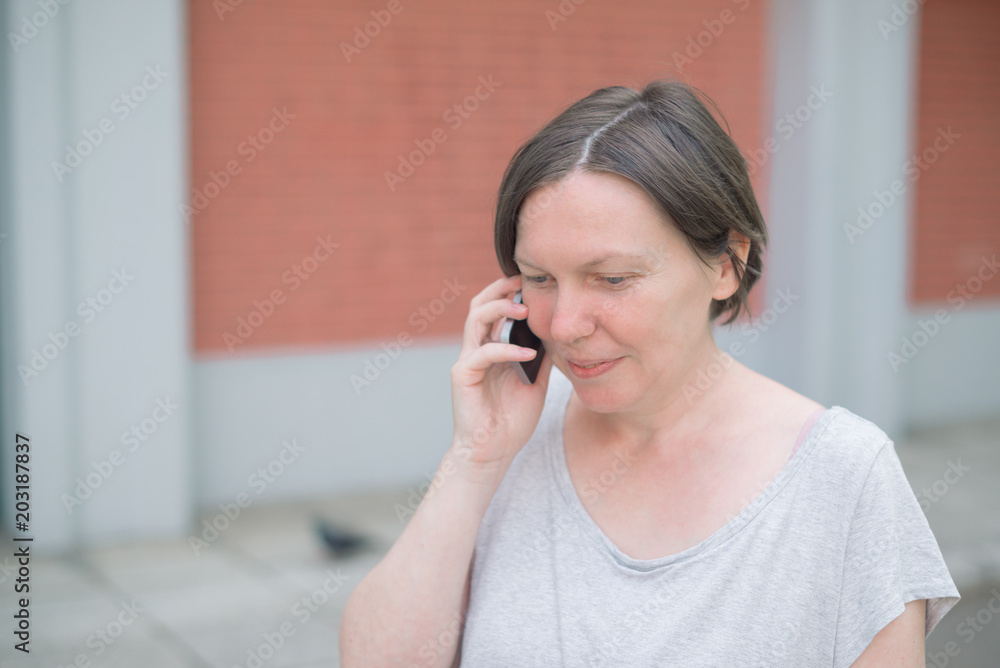 Smiling happy woman talking on mobile phone on the street Smiling happy woman talking on mobile phone on the street