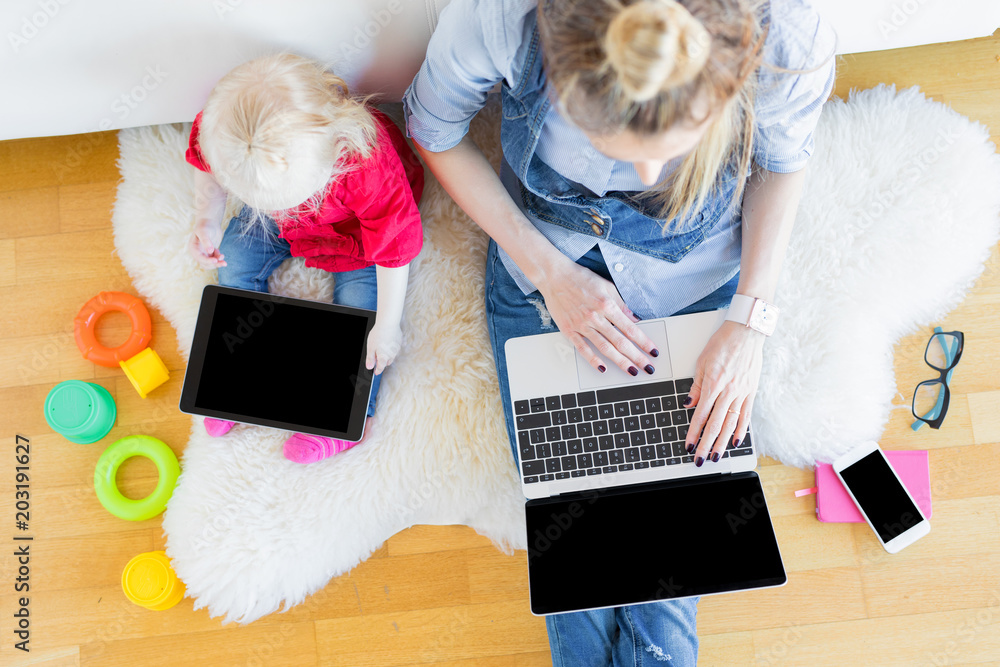 Mom and daughter using tech gadgets together Mom and daughter using tech gadgets together