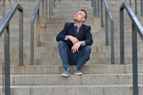 man sitting on the stairs and looking up