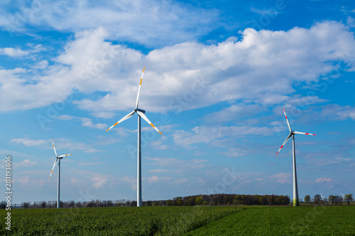 Windräder auf einem Feld drehen sich und produzieren Ökostrom