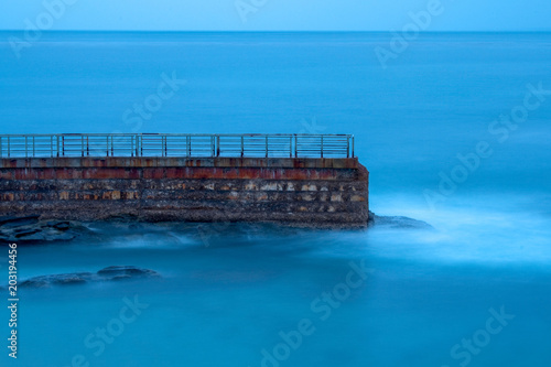 Landscape of the Children’s Pool wall in La Jolla with soft blue ocean water 