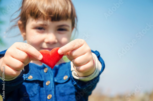 The heart is in the hands of the child. Selective focus. 