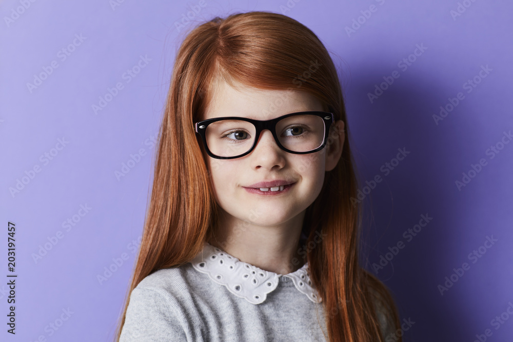 Smiling girl in glasses with long, red hair