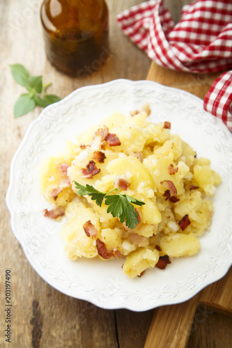Potato salad with fried bacon and parsley