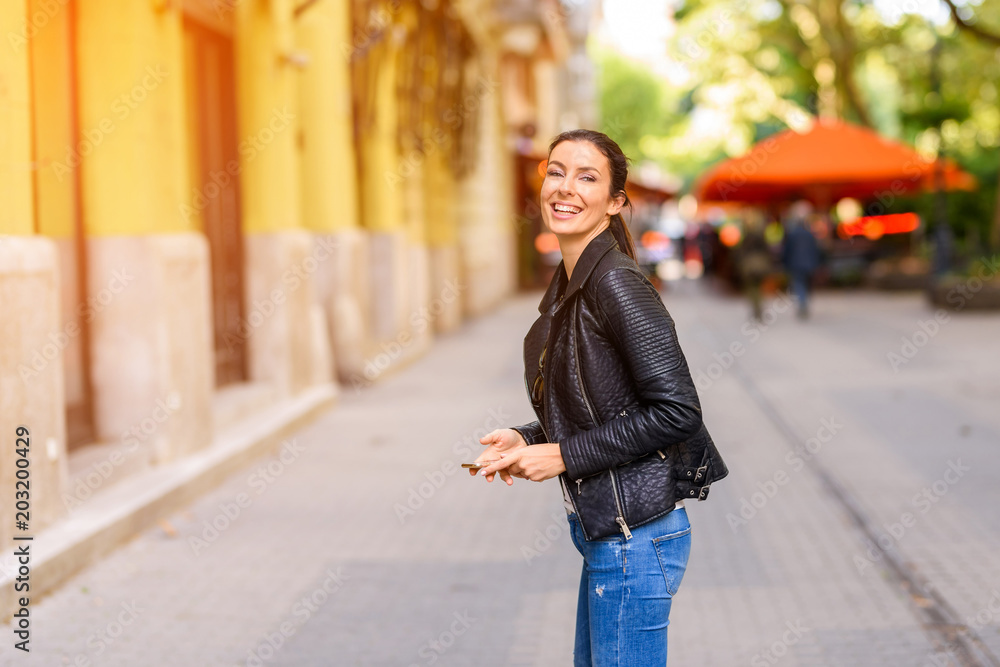 A happy young woman enjoying the autumn in a Central European ci A happy young woman enjoying the autumn in a Central European ci