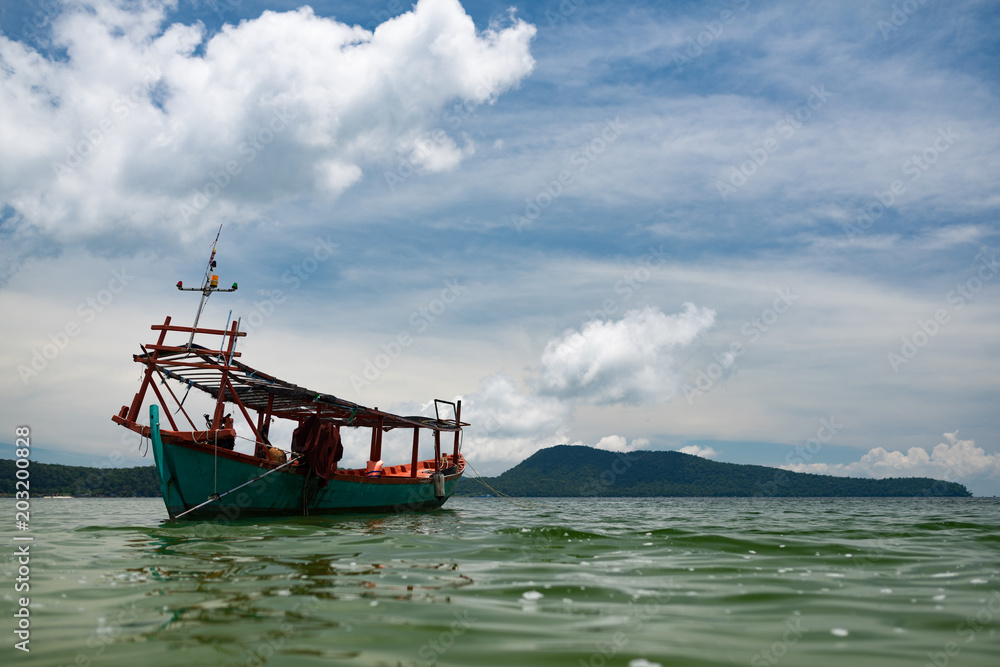 Green Longtail boat moored in Saracen Bay in Koh Ron Samloem, Cambodia. Beautiful clouds on the sky in the background. Green Longtail boat moored in Saracen Bay in Koh Ron Samloem, Cambodia. Beautiful clouds on the sky in the background.