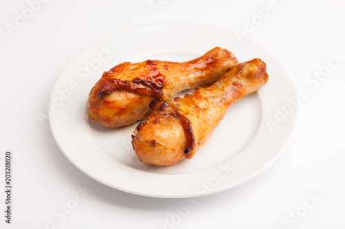 beautiful photo close-up menu of fresh delicious chicken legs on a plate on a white background