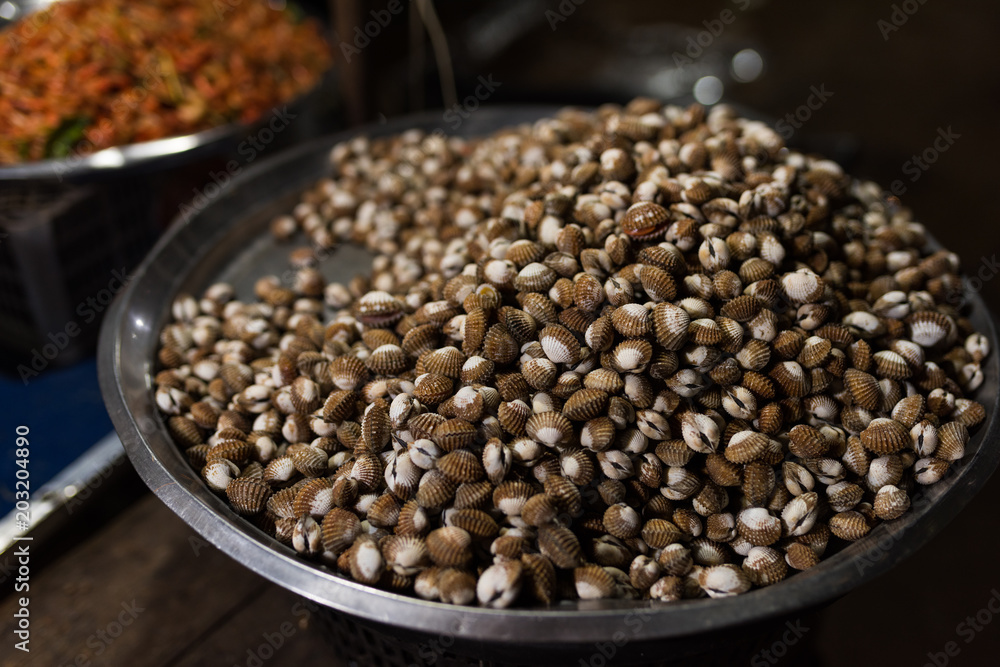 Cambodian night street food market with boiled sea shell I iron bowl ...