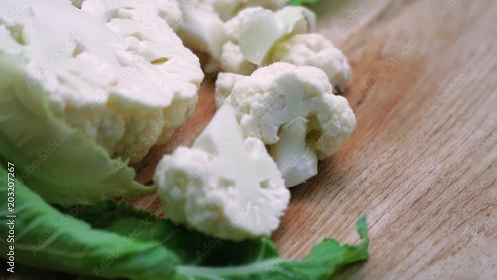 Fresh cauliflower are on the rotating wooden table. Macro. 4K Fresh cauliflower are on the rotating wooden table. Macro. 4K
