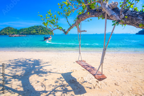 Relaxing with wooden swing under the tree on tropical beach, Scenery of beautiful destination, Koh Phakbia island, Andaman sea, Krabi province, Thailand.