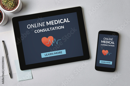 Online medical consultation concept on tablet and smartphone screen over gray table. All screen content is designed by me. Flat lay