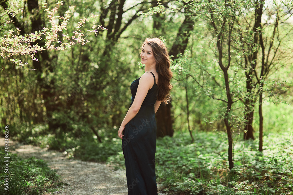The beautiful girl walking along forest The beautiful girl walking along forest