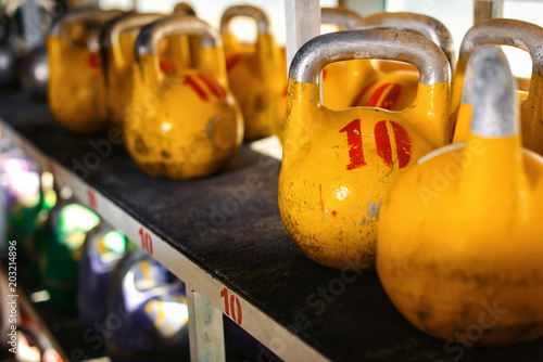 Sport equipment in gym. Kettlebell in rows background with sunlight effect. Fitness training. photo