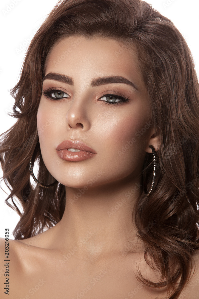 Obraz premium Beauty portrait of a young girl with natural make-up and natural lip color. Hairstyle curls, chestnut hair color. White isolated background.