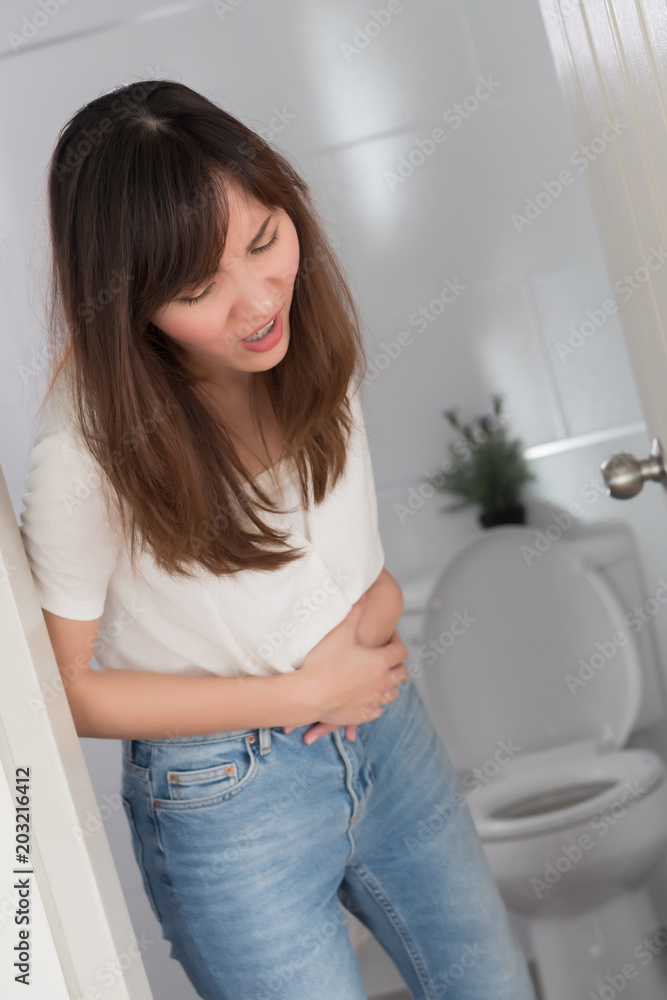 woman with diarrhea symptom; sick woman suffering from diarrhea