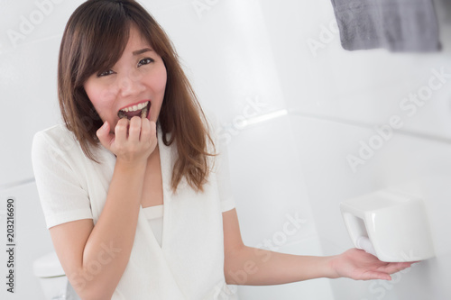 screaming woman with no toilet paper in restroom; portrait of asian woman finding no toilet paper left in the bathroom or wc, concept of crisis, trouble, problem; asian young adult woman model