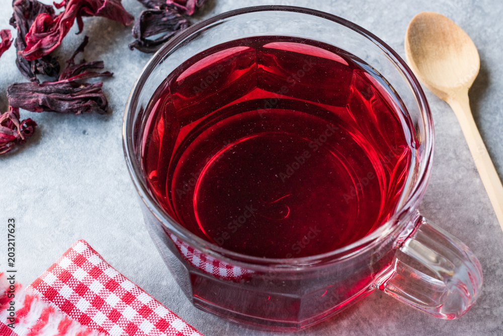 Red Hot Hibiscus Tea in a Glass Mug with Dry Hibiscus Tea Leaves. Red Hot Hibiscus Tea in a Glass Mug with Dry Hibiscus Tea Leaves.