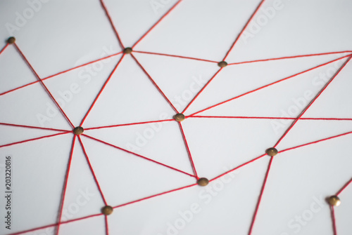 Background. Abstract concept (idea) of network, social media, internet, teamwork,  communication. Thumbtacks linked together by red thread. Isolated. Entities connected.
