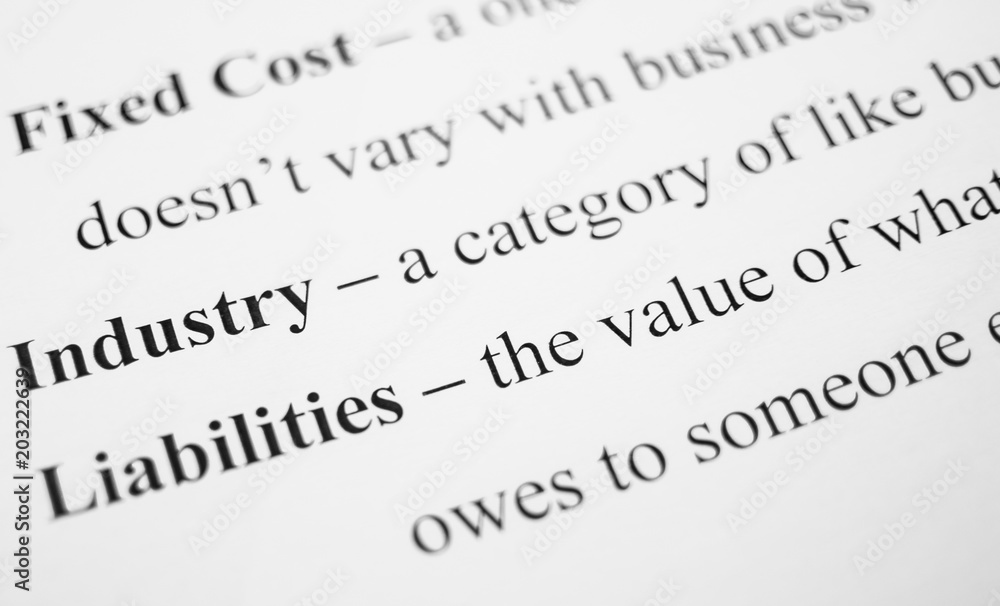 Closeup of popular business-related terms and their respective definitions on the white paper.