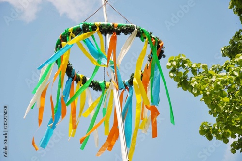 Ein Maibaum und Pfingstbaum mit bunten Bändern hübsch geschmückt 